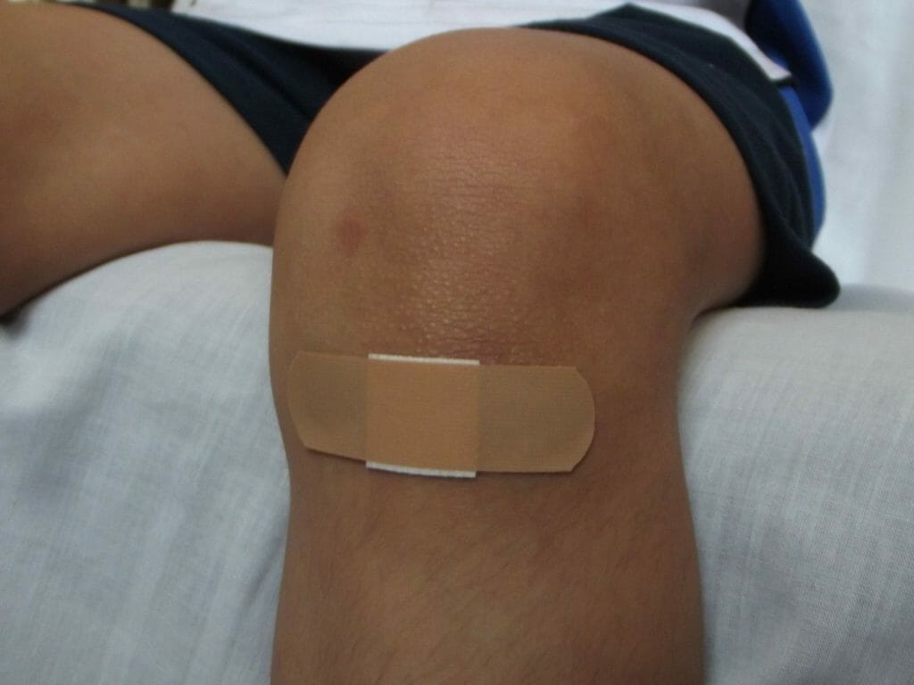 Een huidkleurige pleister op een knie