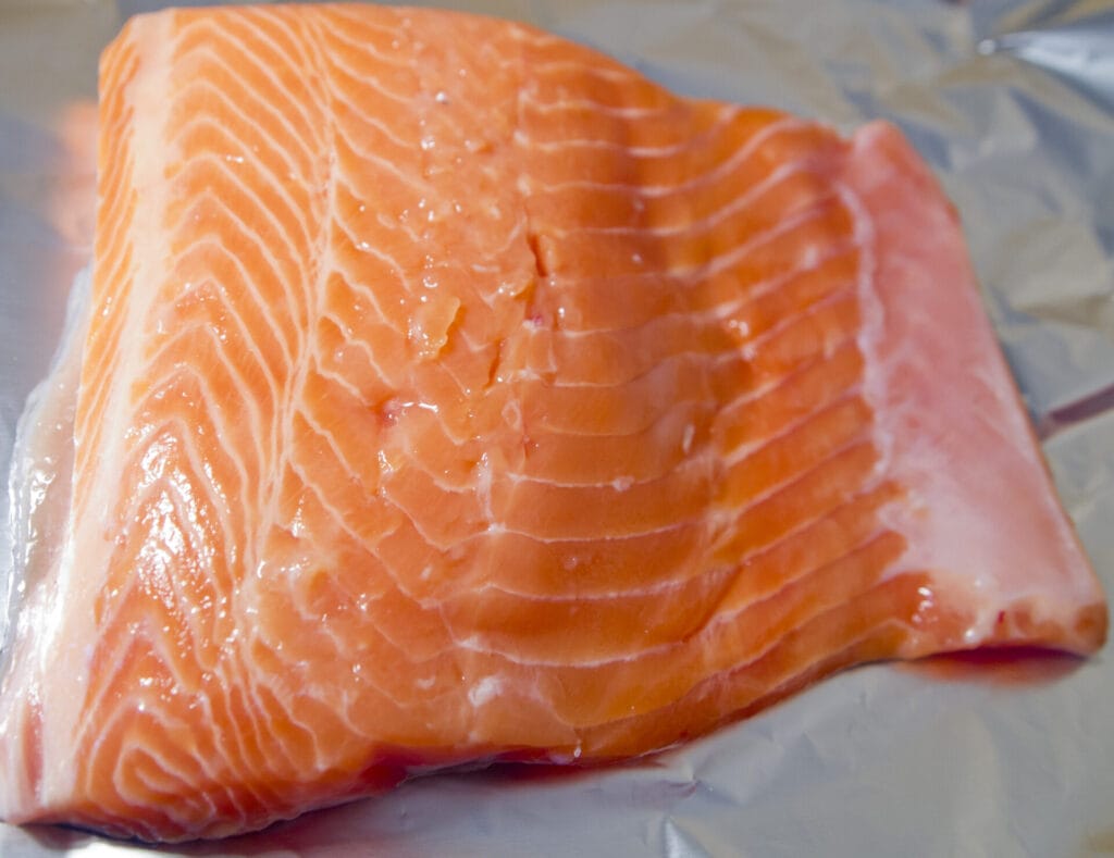 Rauwe zalmmoot met duidelijk zichtbare vetlagen, een voorbeeld van vette vis met vitamine D